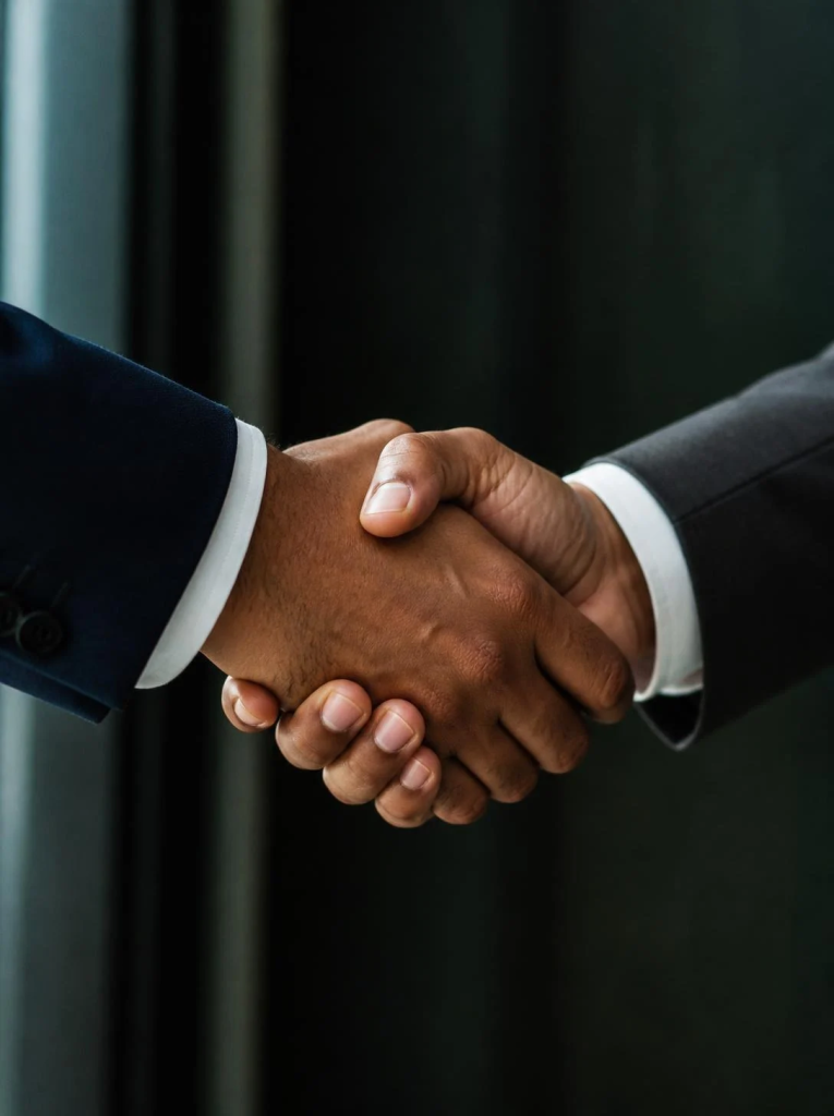 Two business partners in suits shaking hands to agree a deal