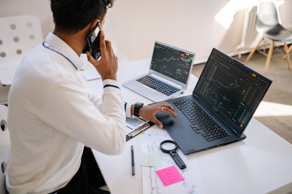 Business owner tracking overdue payments on his laptops while on a call