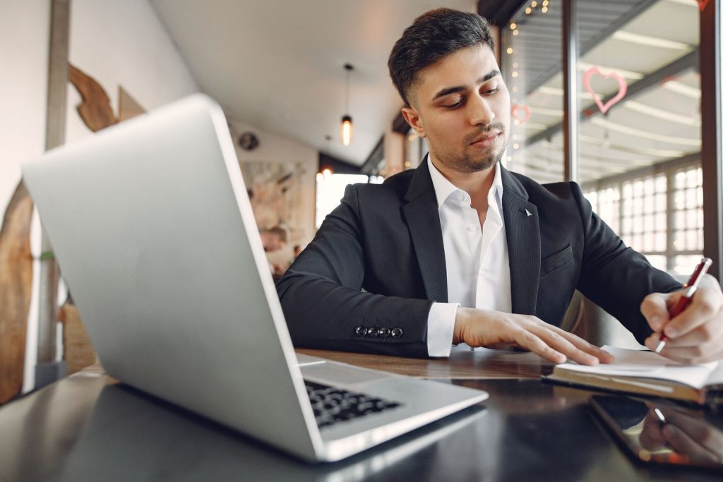 Indian businessman verifying a new customer on his laptop