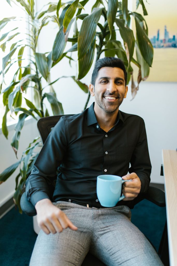 Smiling Indian business owner who runs bulk voice call campaigns